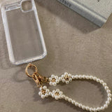 Elegant pearls connect, with a two-way charm. A mobile phone strap & bag chain accented with rose gold petite flowers.