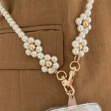 Elegant pearls connect, with a two-way charm. A mobile phone strap & bag chain accented with rose gold petite flowers.