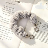 "Add a soft pop of color to your daily essentials" Fluffy smartphone wrist strap with holder sheet