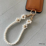 Elegant pearls connect, with a two-way charm. A mobile phone strap & bag chain accented with rose gold petite flowers.